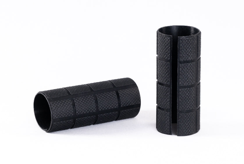 Two black textured cylindrical objects on a white background