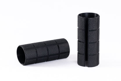 Two black textured cylindrical objects on a white background