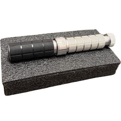 Tactical flashlight on a textured gray stand with a white background